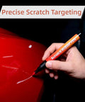 Hand using 2 Pack Car Scratch Removal Pen And Auto Paint Repair Brush Kit For All Colors Clear Finish Touch Up Paint on red surface