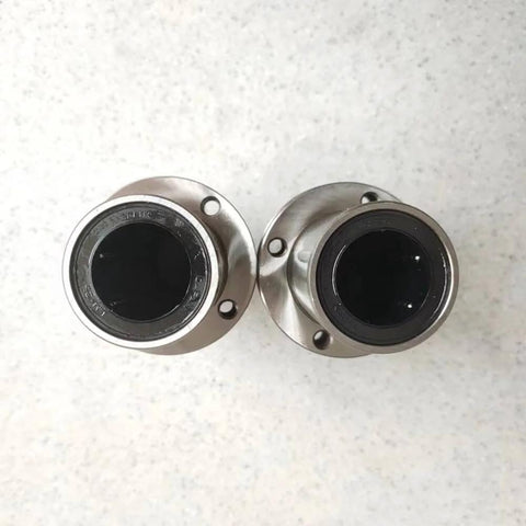 Two Flanged Linear Bearing Bushing LMF25UU Chrome Steel SAE 52100 With Rubber Sealed Closure on a light surface