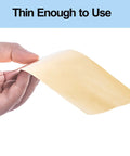 Person holding a thin sheet of Brass Shim Stock Assortment Set 6 Inch By 4 Inch For Home Shop Projects, Five Thicknesses 0.001 0.002 0.003 0.005 And 0.01 Inch, Polished Brass Sheets, Handy For Jewelry Making, Model Building, And Repairs.