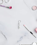 Stainless Steel Cotter Pins And Wavy R Shape Fastener Clips For Mechanical Assembly, Hitch Security Bolt Locks That Stop Loosening And Keep Your Gear Safe While Working Hard On Jobs on a marble surface with brushes and cosmetics.