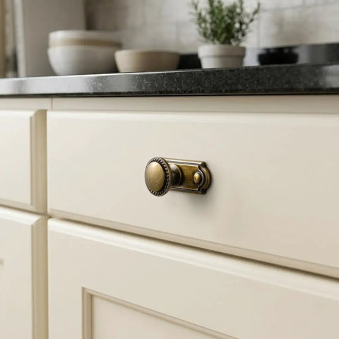 Antique Brass Cabinet Knobs With Industrial Backplates on cream kitchen drawer for rustic farmhouse vibe