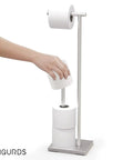 Hand using Freestanding Toilet Paper Holder With Storage For Jumbo Rolls Holds Up To Four Rolls No Fuss Easy Access Stand Up Bathroom Organizer Modern Sleek Design Keeps Your Restroom Neat And Ready, stainless steel.