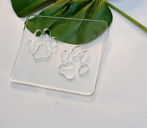 Badass Double Paw Print Router Template For Heavy Duty Woodworking Resin Inlay Cavities Clear Quarter Inch Acrylic Stencil Tracing Guide on green leaves.