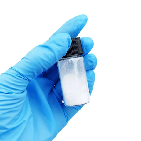 Gloved hand holding a vial of Boron Nitride Nanotubes BNNTs Top Shelf Lab Grade White Nano Powder 60 Nanometer Diameter And 0.1 To 20 Micron Length Great For Radiation Shielding Optoelectronics Heat Dissipation And Nanosensor Applications.