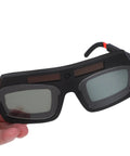 Kickass Auto Darkening Welding Goggles Solar Powered Wraparound Safety Eyewear, lightweight design, held in hand, visible lenses.