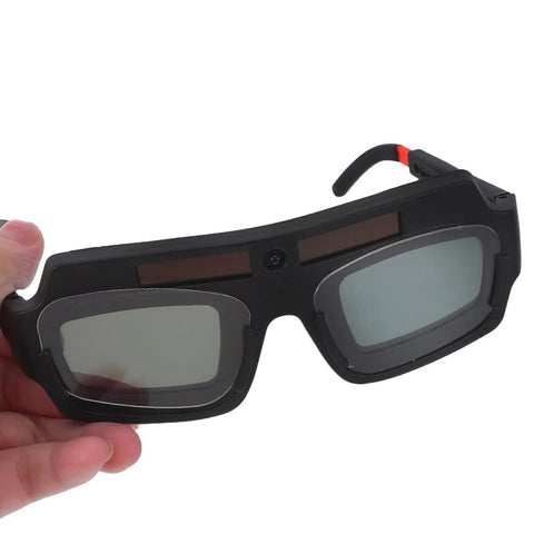 Kickass Auto Darkening Welding Goggles Solar Powered Wraparound Safety Eyewear, lightweight design, held in hand, visible lenses.
