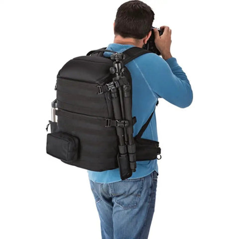 Back view of person wearing Shoulder Camera Bag And Laptop Backpack With All Weather Cover for 15.6 Inch Laptops, camera in hand.