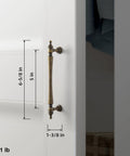Side view of Six Pack 5 Inch Antique Brass Cabinet Pull with ornate tapered handles and decorative finials installed on white cabinet.