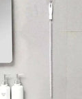 Flexible Drain Snake Cleaner Brush That Kicks Out Greasy Gunk Reusable Spiral Hair Removal Tool With Comfort Grip Handles For Sinks Showers And Bathtubs In White hanging on wall.
