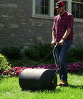 Man using Powerful 270 Lb Poly Lawn Roller For Push Or Tow With Easy Turn Tethered Plug And Quick Filling Drum 18 By 24 Inches Brinly PRC-241BH-A