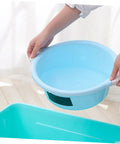 Person holding a light blue plastic basin above a sink area