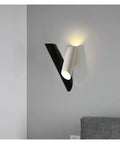 Rock Solid Black Iron Wall Sconce With Pivot Led Fixture And Chill Warm Glow Modern Minimalist Bedside Lighting mounted on grey wall.