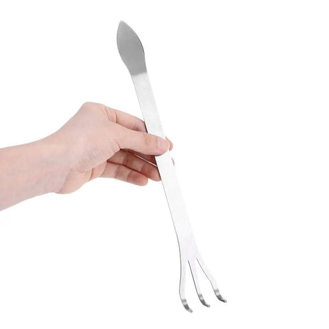 Hand holding Root Rake For Bonsai And Garden Soil Loosening Three Prong Stainless Steel Tool With Ergonomic Handle For Outdoor Yard Work