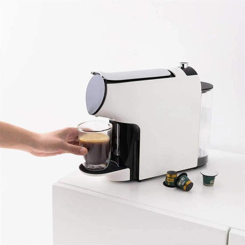Durable Smart Capsule Coffee Machine With Drip Free Design No Mess One Tap Operation Two Modes Italian Espresso And American Coffee Compact Electric Brewer For Home Use, shown brewing espresso into a glass mug with capsules beside it.
