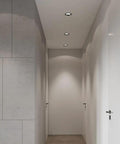 saditesdk 12Pack Led Recessed Lighting - 5W/7W Black Recessed Lights mounted in a modern hallway with sleek walls.