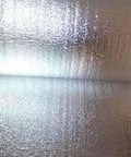 Double Sided Reflective Foam Insulation Roll That Blows Away Utility Bills Blocks Radiant Heat Quick Peel Hang For Attics Walls And Crawlspaces R8 Rated Ultra Thick Five Millimeter Core Seventy Two By Two Hundred Feet Made In Usa showcasing shiny, reflective surface of the insulation roll.