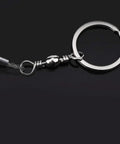 Close-up of Beefy Stainless Steel Portable Wire Saw showing the four-strand cable and metal keyring attachment on a black background.