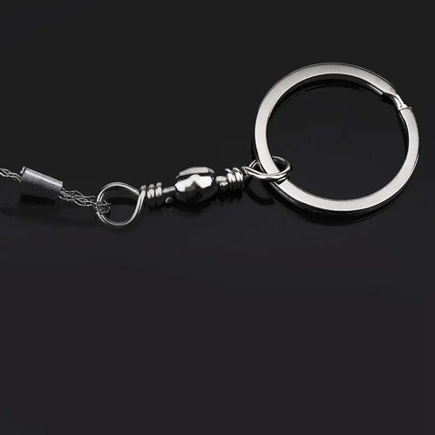 Close-up of Beefy Stainless Steel Portable Wire Saw showing the four-strand cable and metal keyring attachment on a black background.
