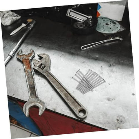 Stainless Steel Countersunk Flat Head Self Tapping Screws for Furniture Assembly on workbench, next to wrenches and tools.