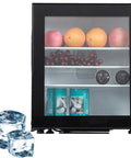 Compact Upright Mini Freezer Featuring A Sleek Black Glass Door With Energy Efficient Cooling That Runs Dead Quiet At Twenty Eight Decibels Ideal For Dorms Offices Or Small Bedrooms With Plug And Play Design displaying fruits and drinks inside, with ice cubes, sleek design.