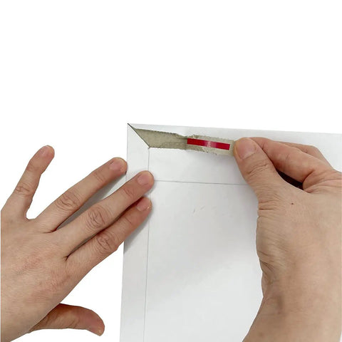 Hands sealing a 22 Pack White Rigid Mailers 9.25 X 11.5 Inches Heavy Duty Cardboard Mailer