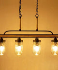 Farmhouse Black Mason Jar Chandelier for Kitchen Island with faux wood and glass shades, warm cozy light on dining table.