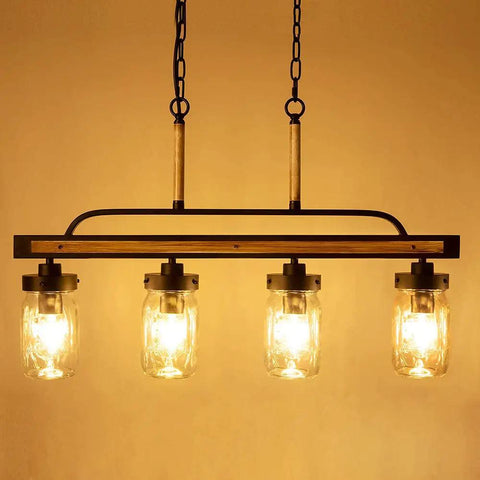 Farmhouse Black Mason Jar Chandelier for Kitchen Island with faux wood and glass shades, warm cozy light on dining table.