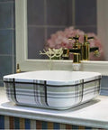 Premium Ceramic Vessel Sink, Snazzy Square Countertop Basin on a marble counter beside a floral arrangement, showcasing stylish design.
