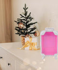 Lijinhe mini suitcase favor boxes with wheels, pink and purple, two shown on a white table beside a Christmas tree