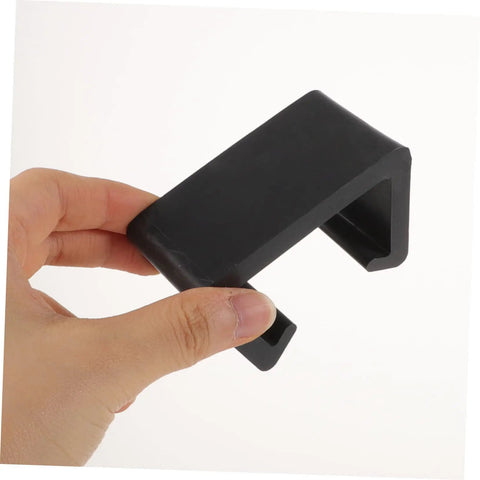 Hand holding a black clip from the 12 Piece Outdoor Furniture Clips For Sofa And Patio Wicker Chairs Easy To Install No Tools Needed Sturdy Rattan Connectors For Securing Couches Cushions And Sectionals On Patio Sets
