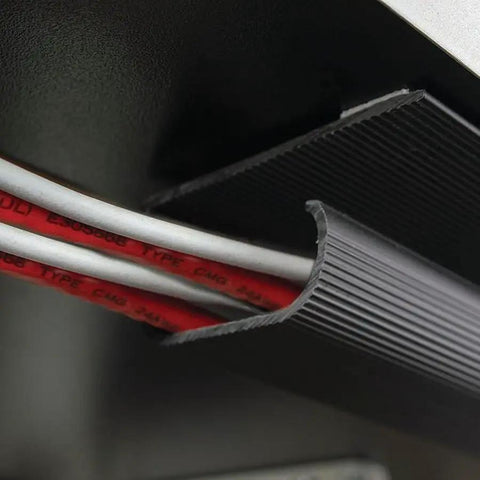 Close-up of 46-inch black J Channel Cable Raceway With Self Adhesive Backing organizing wires under a desk