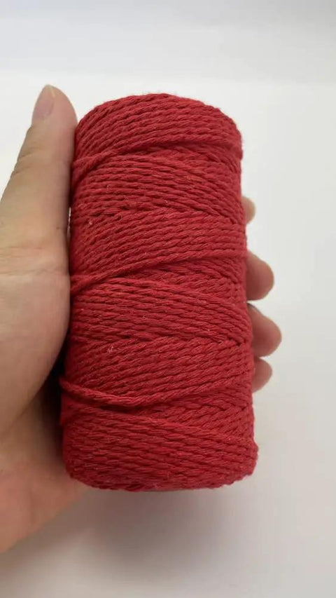 Red roll of Macrame Cord 1.5mm Cotton String Rope For DIY Crafts 109 Yards With 35 Color Options held in a hand