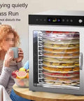 12 Tray Stainless Steel Food Dehydrator With Digital Display And 800 Watt Heating Element drying fruits and vegetables visible through clear window.