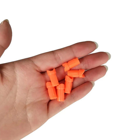 Hand holding orange Half Moon Arrow Nocks 50 Pack Plastic Crossbow Nocks For 7.6mm ID Bolts Orange Replacement Tips For Target Practice