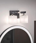 Two-Light Marette 13.5-Inch Vanity Light in Brushed Nickel with Satin Etched Cased Opal Glass above round mirror