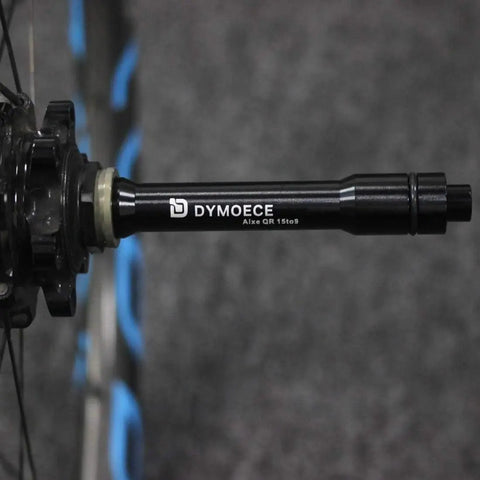 Close-up of aluminum alloy Front 15mm Thru Axle to 9mm Quick Release Skewer Adapter for 100mm Forks mounted on a bike wheel hub.