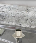 Close-up view of Heavy Duty Universal Faucet Hose Guide In Brushed Nickel mounted on a kitchen sink deck.