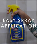 Hand holding Piranha Wallpaper Remover Spray Pro Grade Glue Stripper Fast Acting Liquid Clear Finish 32 Ounce with easy spray application