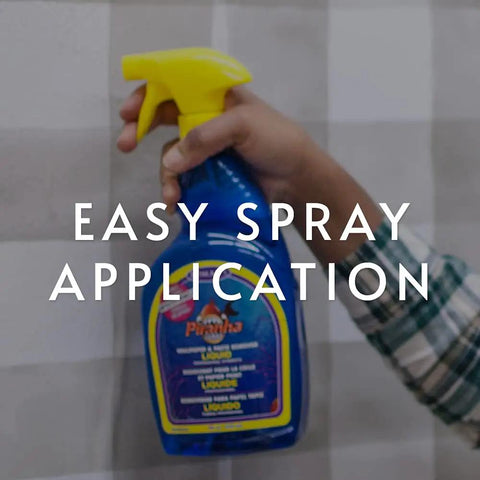 Hand holding Piranha Wallpaper Remover Spray Pro Grade Glue Stripper Fast Acting Liquid Clear Finish 32 Ounce with easy spray application