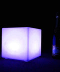 10 Inch Rechargeable LED Cube Light With Remote, 16 RGB Colors, glowing blue beside a bottle in dark setting