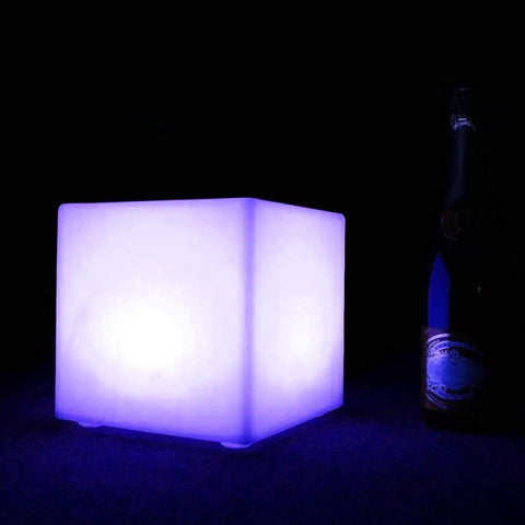 10 Inch Rechargeable LED Cube Light With Remote, 16 RGB Colors, glowing blue beside a bottle in dark setting