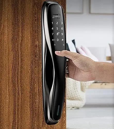 Heavy Duty Smart Door Lock Featuring Biometric Fingerprint Scanner App Control Passcode Entry Built In Theft Alarm And Long Lasting Battery For Dead Simple Home Protection Setup installed on wooden door with hand entering passcode.