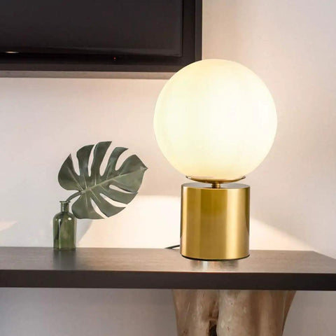 11 Inch Modern Gold Globe Table Lamp With Milk White Glass Shade And Sturdy Metal Base on a shelf indoors