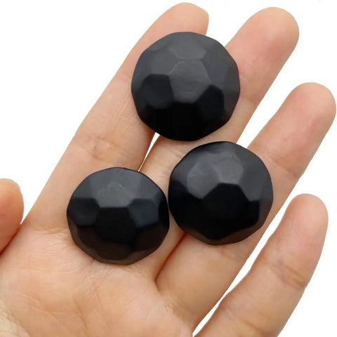 Three matte black upholstery tacks displayed on a hand, part of a Sixty Piece Bundle Of Hella Sturdy Matte Black Upholstery Tacks.