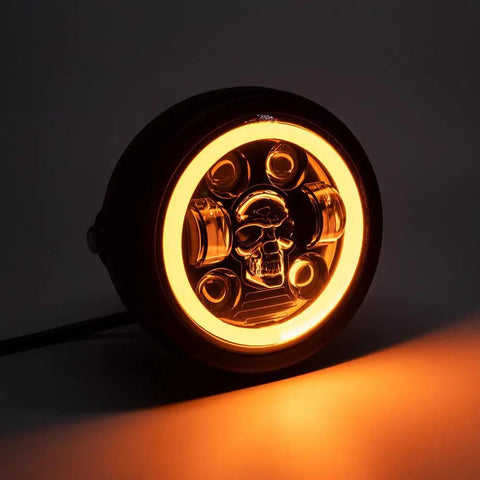Front view of 5.75 Inch Round LED Motorcycle Headlight With Mounting Brackets, skull design, glowing in low light, for Cafe Racer Bobber