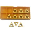 Twenty triangular carbide inserts in a yellow organizer box; TCMT32.51/32.52 and TCMT16T304/16T308 for metal cutting