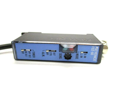 Keyence FS2-60 Fiber Optic Amplifier Sensor front view showing control panel with blue casing, red LED, 8-turn sensitivity trim.