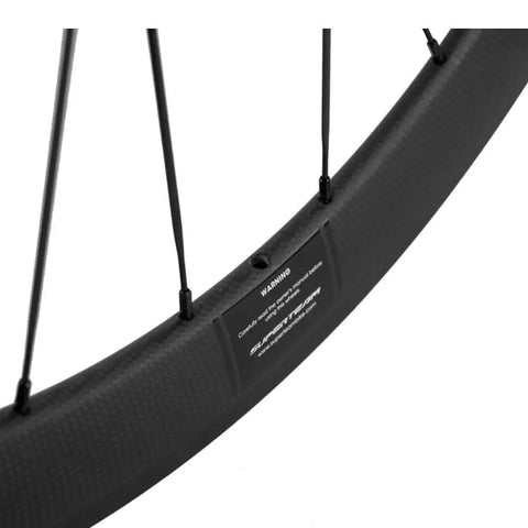 Close-up of 50mm and 23mm carbon road wheelset 700c clincher for Shimano 8 9 10 11 speed with basalt brake surface.