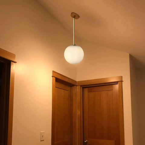 Globe Pendant Light With Matte White Glass And Brass Finish, Dope Modern Mid Century Ceiling Fixture, 8 Inch White Globe shown indoors