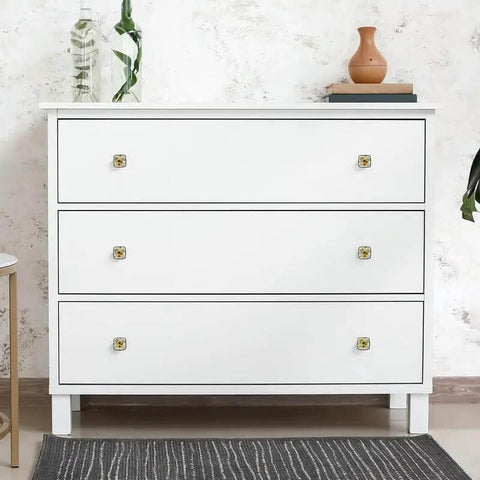 White dresser with sunflower knobs, showcasing Slap These Four Pack Sunflower Cabinet Knobs Onto Your Dressers Or Kitchen Drawers For A Quick Remodel.